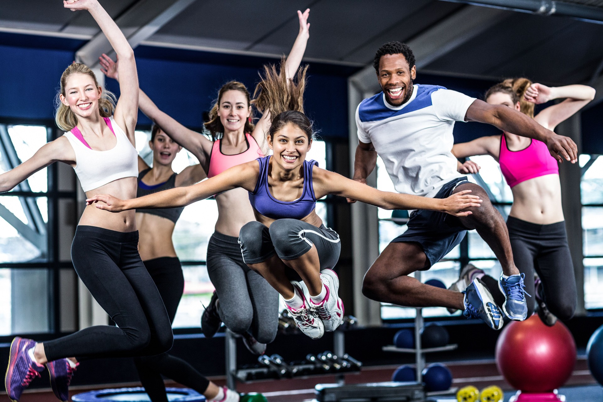 Fit group smiling and jumping